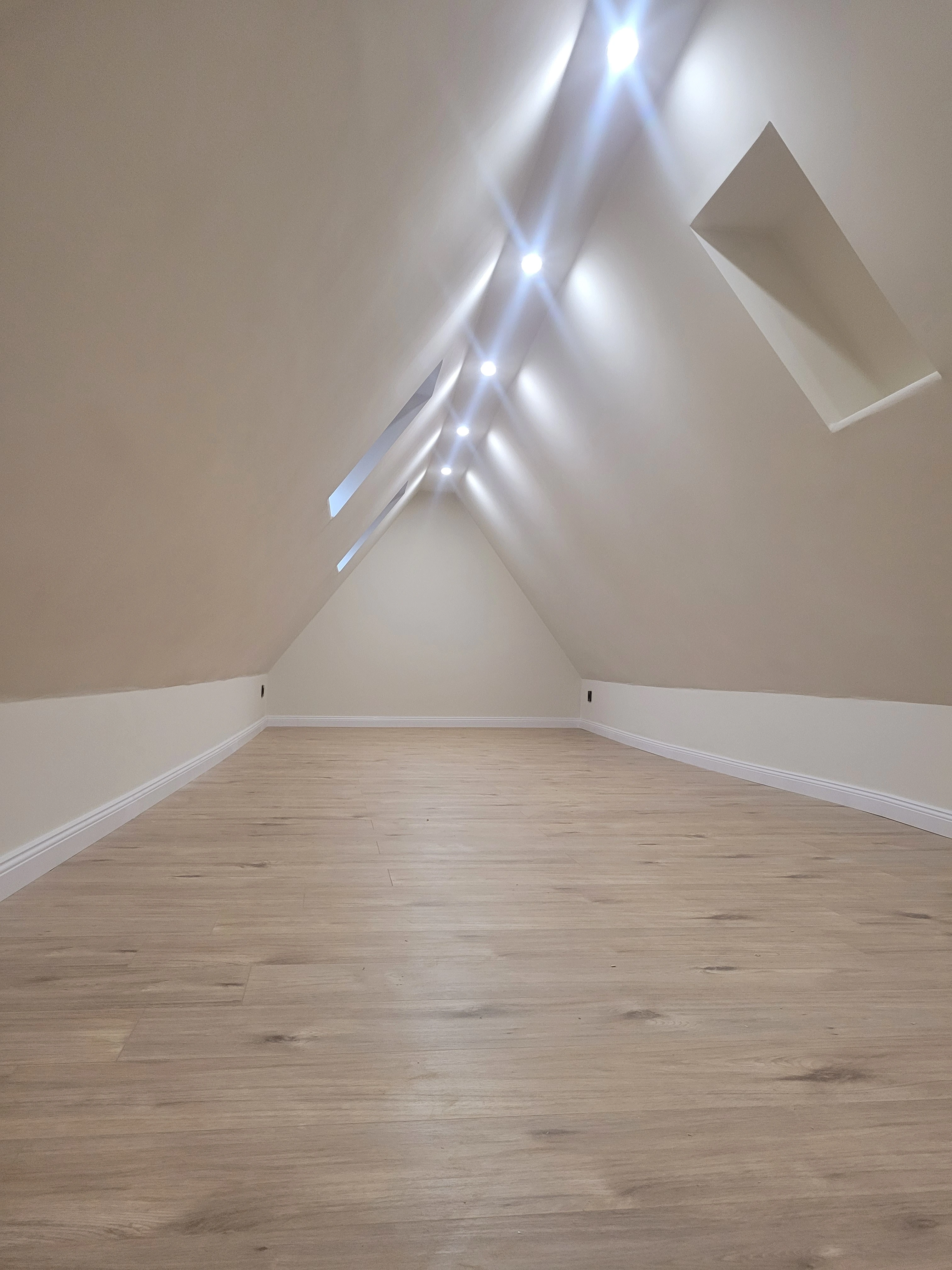 Neu verlegter Laminatboden, kombiniert mit einer frisch gestrichenen Wand und integrierten Smart-LEDs.